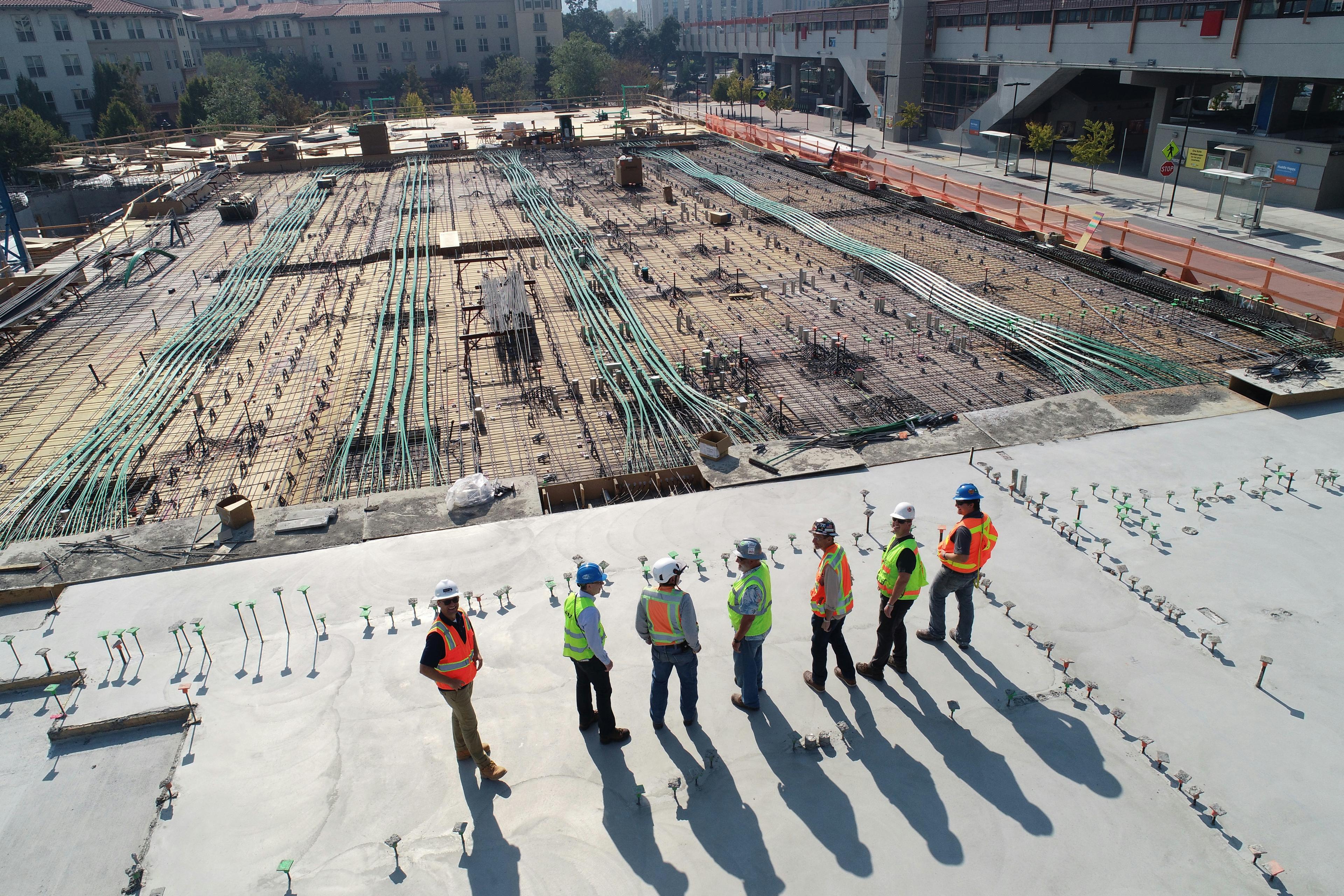 Construction workers laying foundation with concrete and steel
